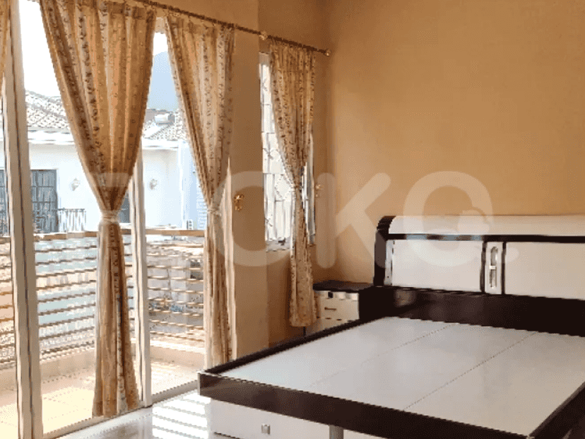A bedroom with a bed, windows with curtains, and a balcony.