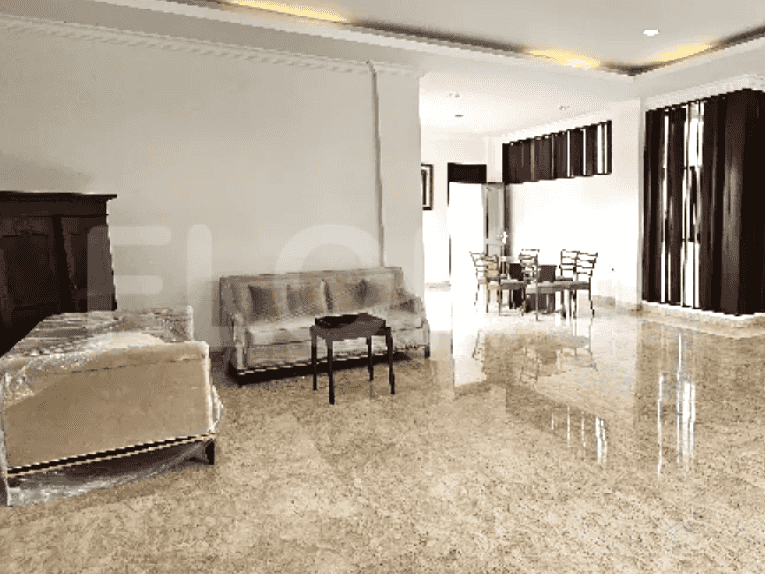 A living room with a dining area featuring a table and chairs and large windows with dark wooden curtains.