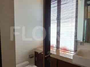 A modern bathroom featuring a toilet, sink, and a window with Venetian blinds.