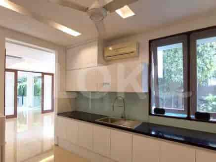 A modern kitchen featuring white cabinets, black countertops, and a view through a window.