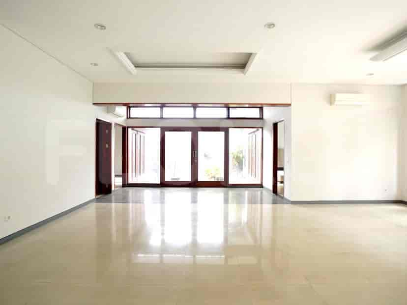 A spacious living room with white walls, tiled floors, and wooden framed doors, offering a clean and airy aesthetic.