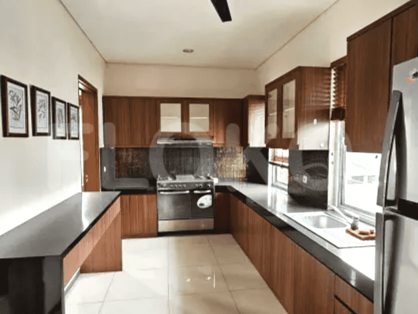 A modern kitchen with wooden cabinets, black countertops, stainless steel appliances, and a gas stove.