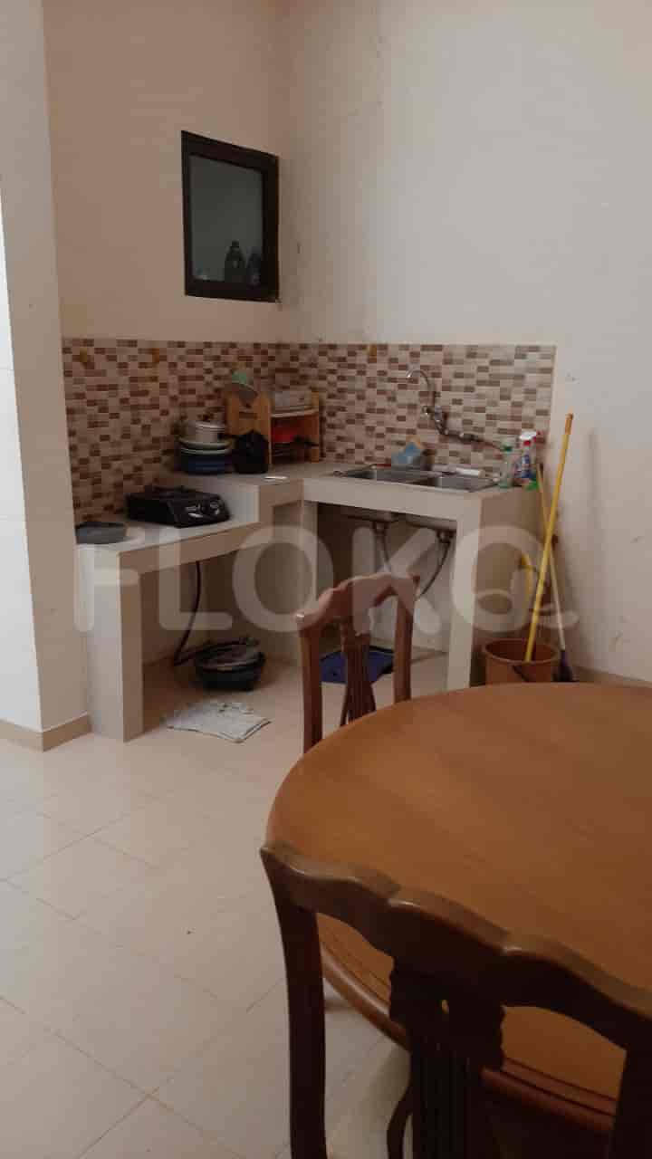 An open kitchen with a sink, cabinets, and a dining table.