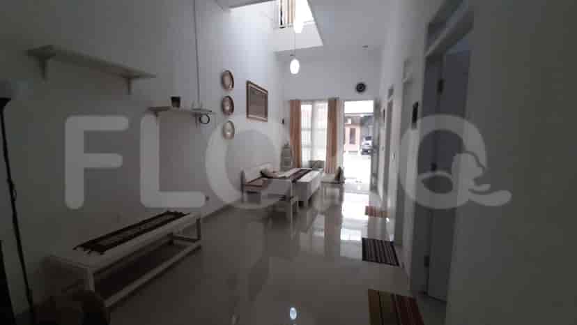 A long hallway with tiled floors and views towards a back door.
