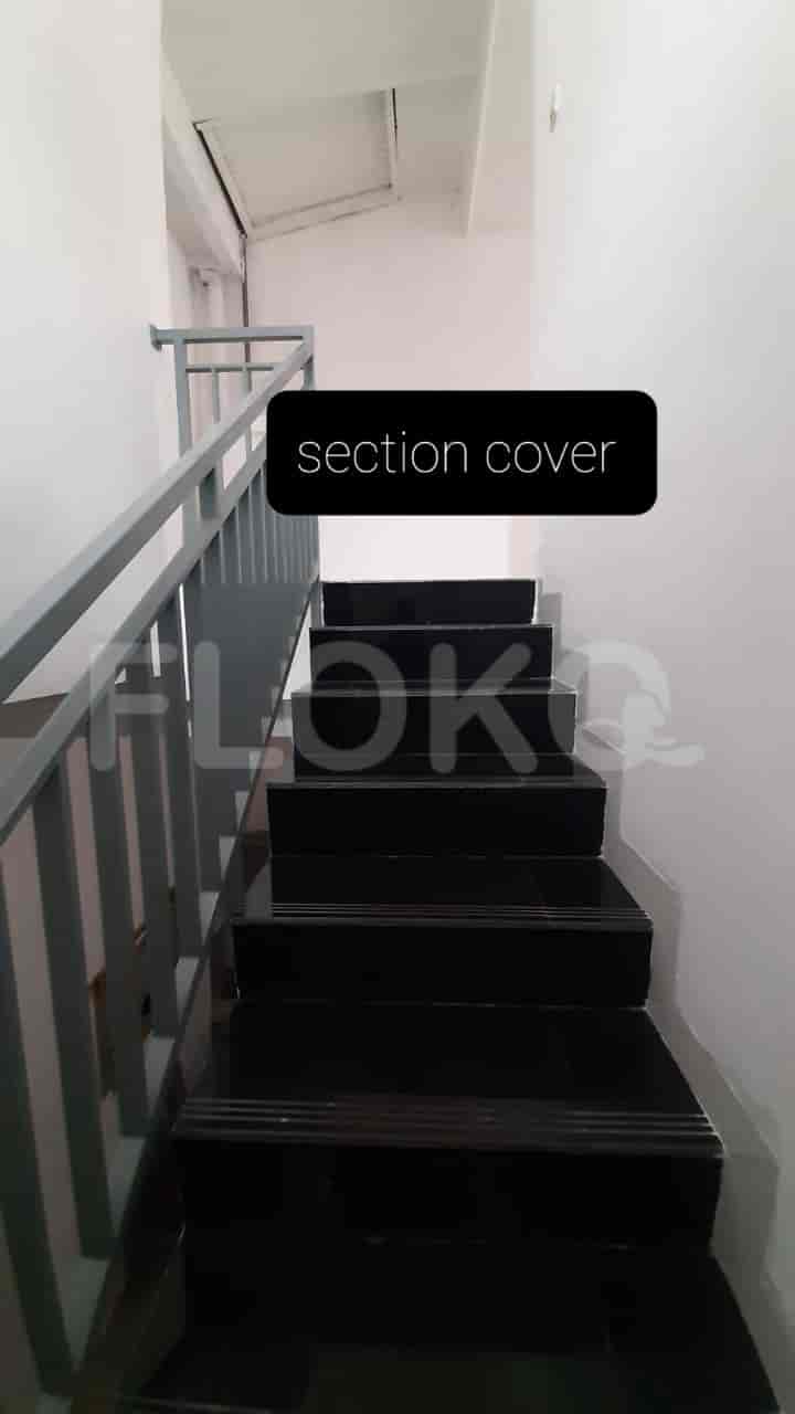 Stairs leading to the upper floor with black tile and grey railings.