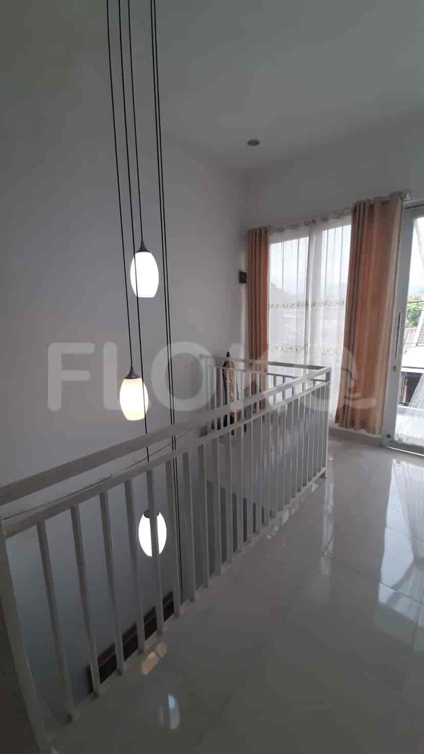 A well-lit upstairs area with a white railing and pendant lights.