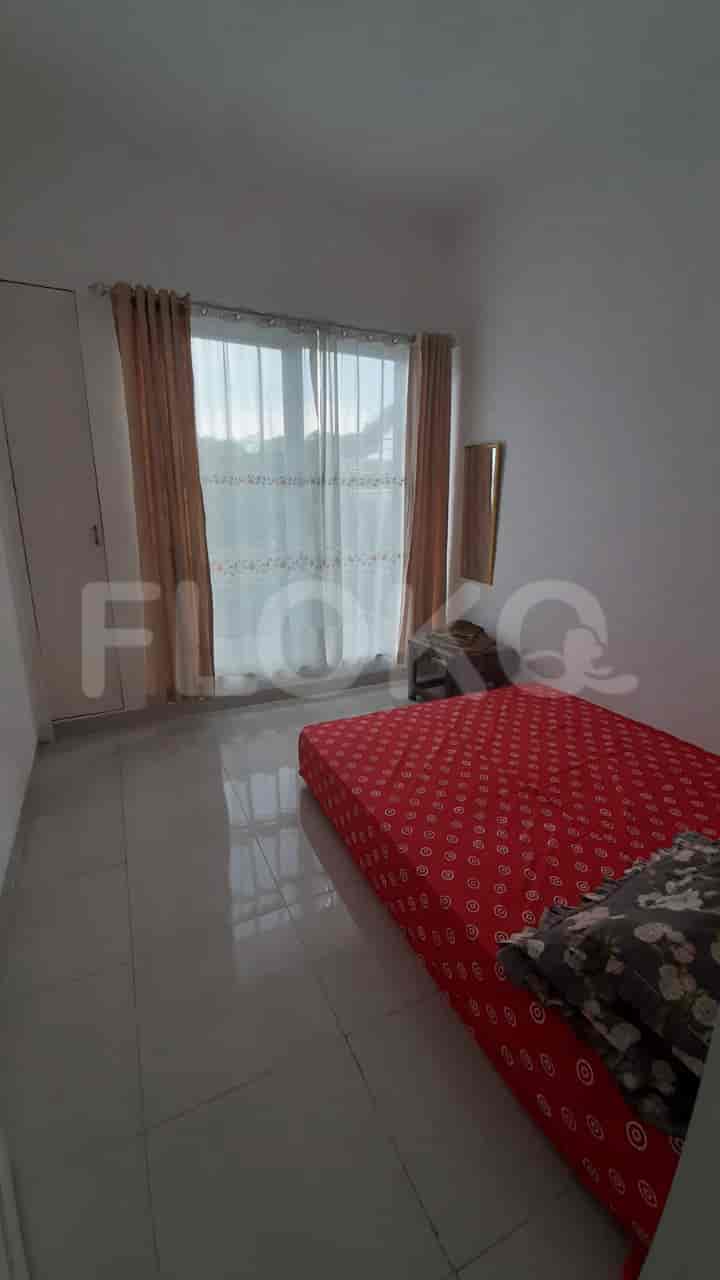 A bedroom with a red bed and a window.