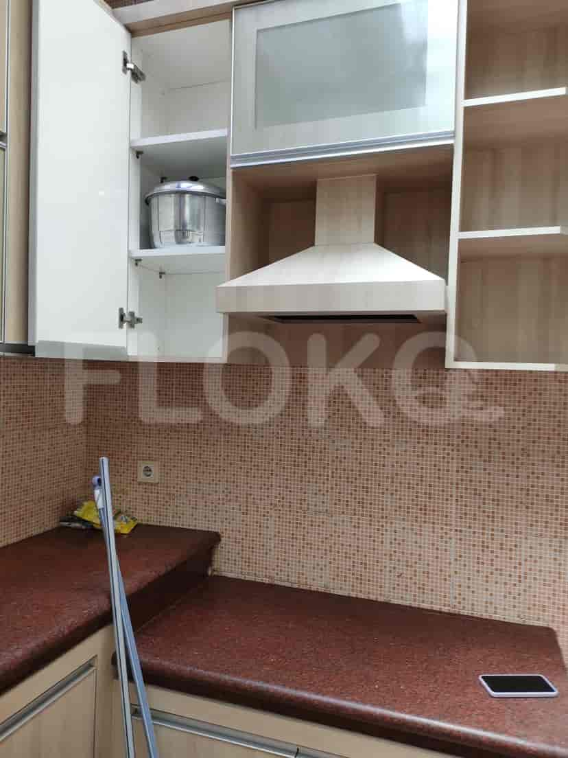 A bathroom with a squat toilet and a blue bucket.