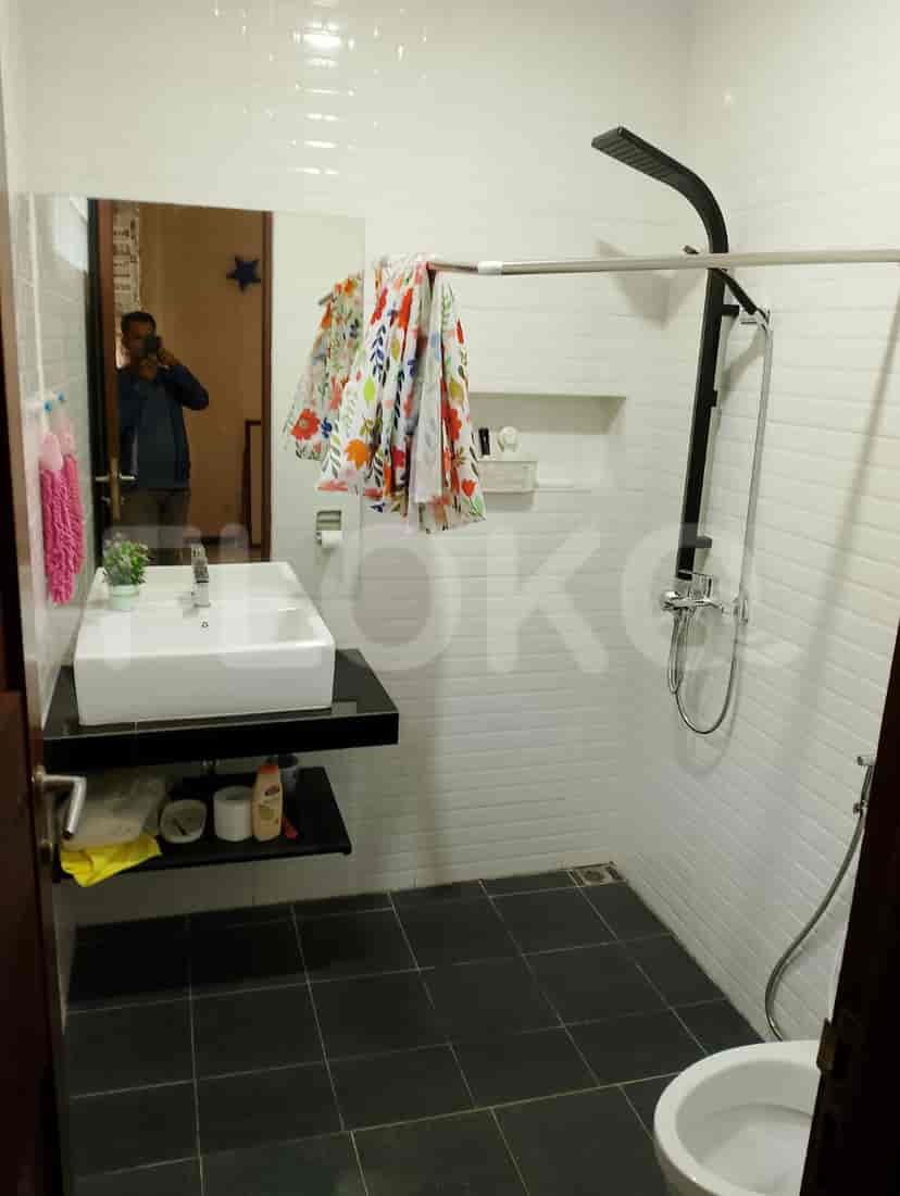 A bathroom with a shower, a white toilet, and tiled walls, demonstrating a clean and functional design.