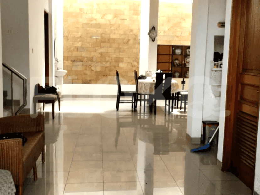 A spacious interior showing a dining area with a brick wall, tiled flooring, and a clock.