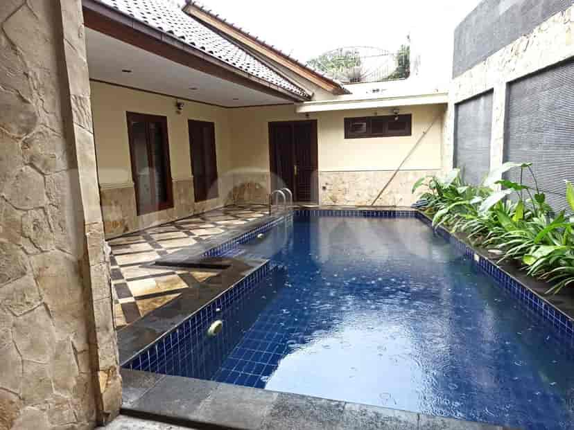 An outdoor area with a swimming pool, patio, and surrounding foliage.