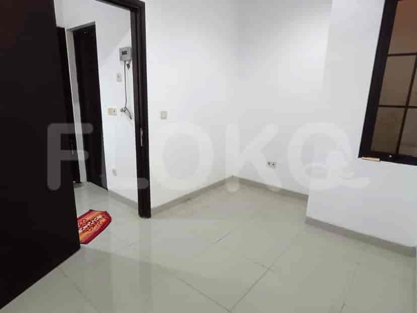 A bedroom with white walls, tiled floors, and a door leading to the outside.
