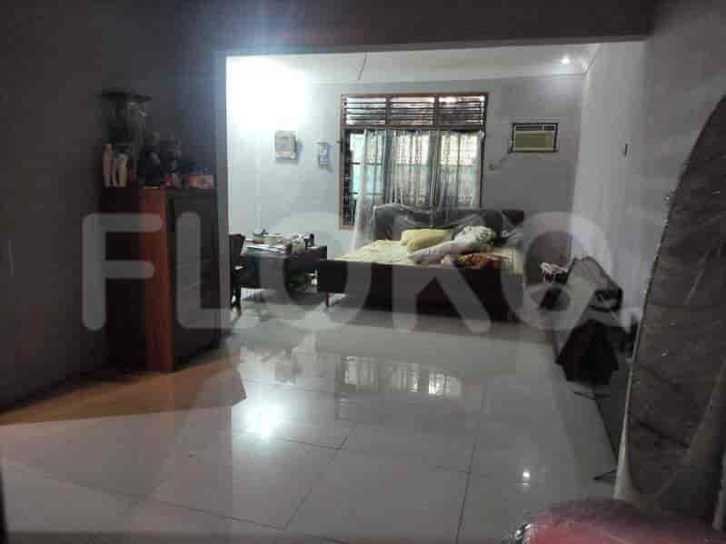 A living room featuring tiled floors, a simple bed, and a window.