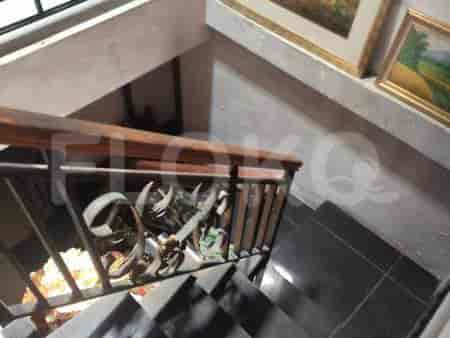 A staircase with dark tile steps and metal and wood railing.