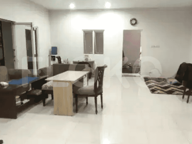 A living room with a sofa, dining table, and a doorway leading to another room.