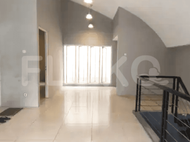 A hallway with high ceilings, grey walls, and a staircase.