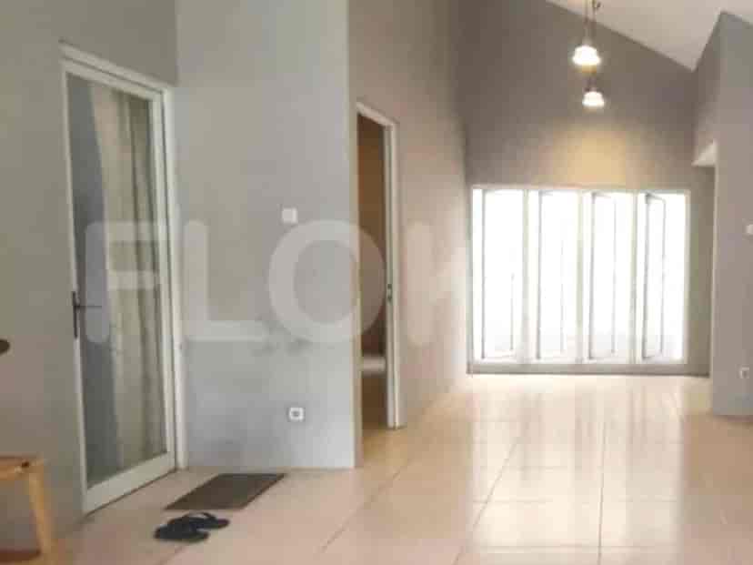 A bright hallway with tiled flooring, grey walls, and a high ceiling, leading to different rooms.