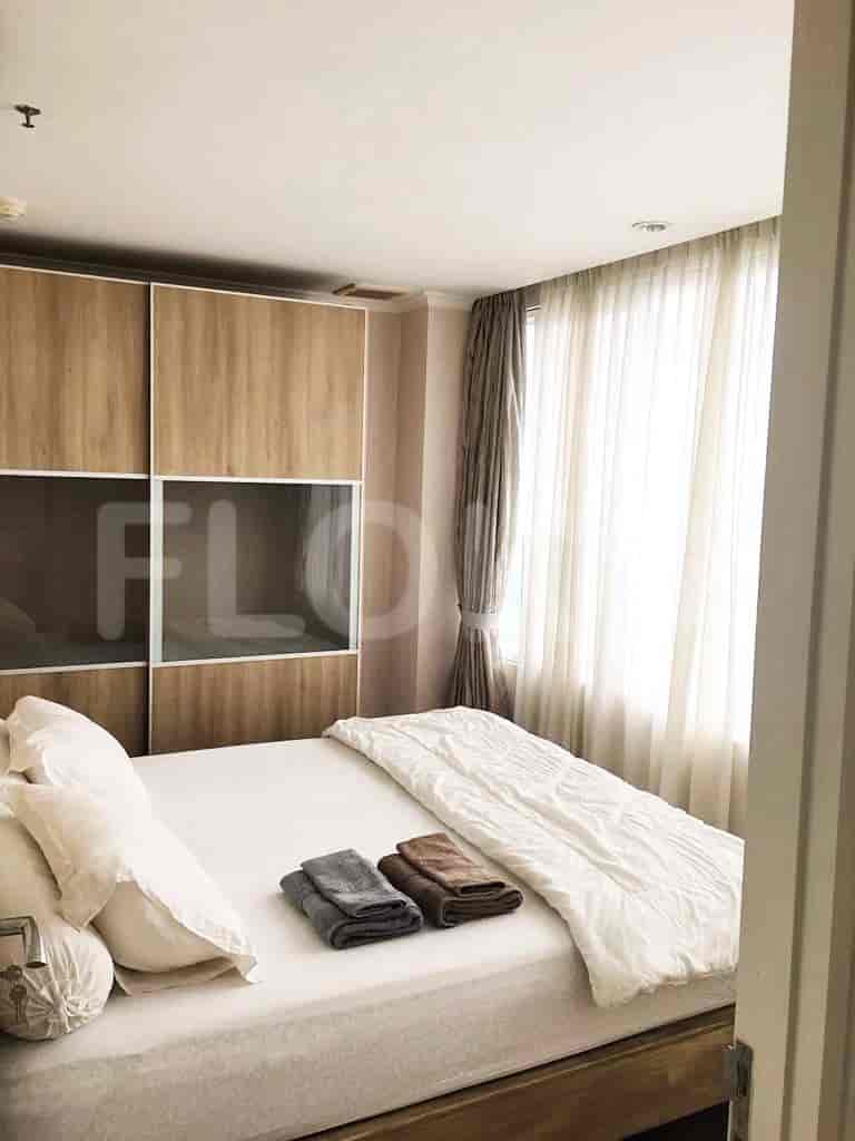Kamar tidur yang nyaman dengan tempat tidur ganda, lemari, dan jendela besar dengan gorden.