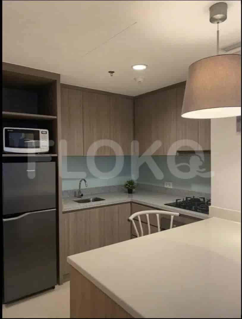 The kitchen has a refrigerator, microwave and countertop with cabinetry.