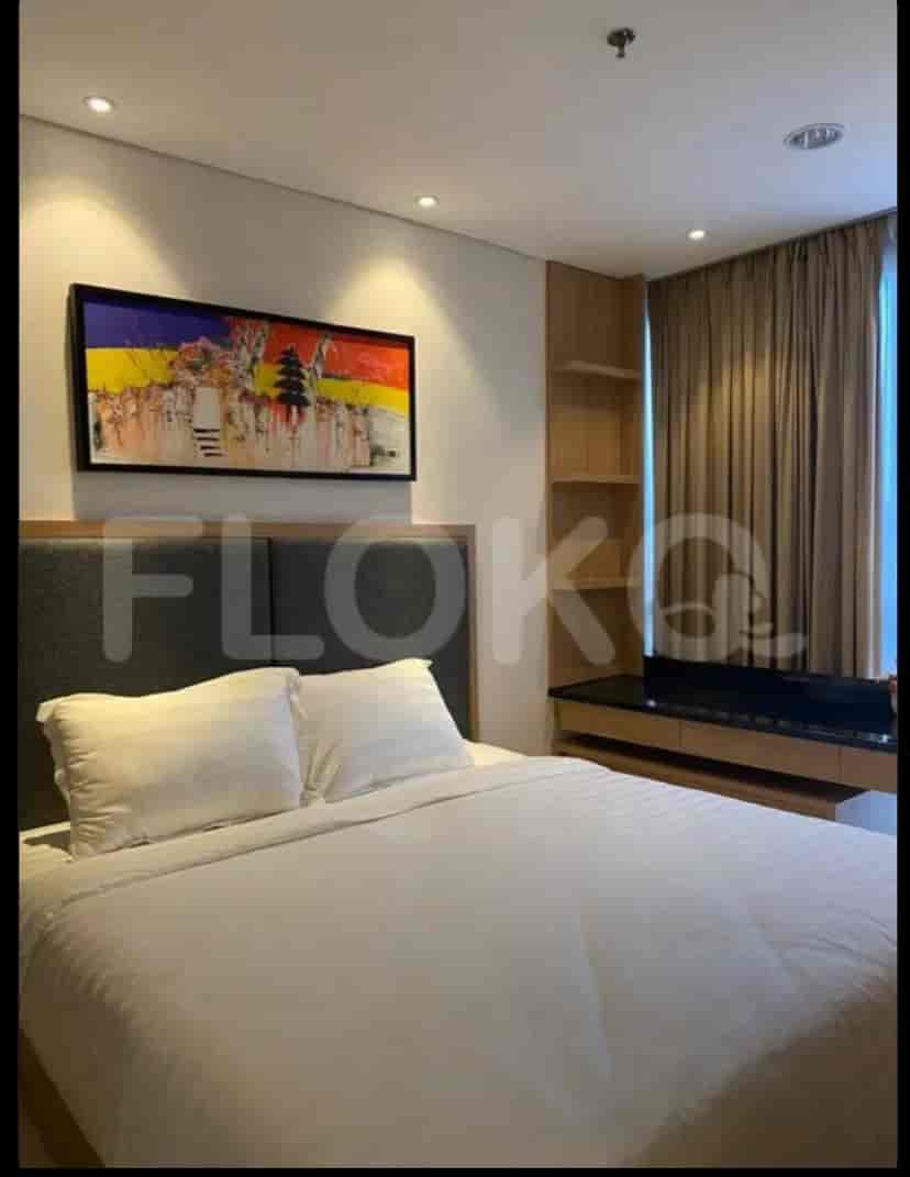 Bedroom with a bed, art, and curtained windows.