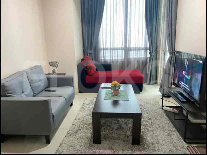 A modern living room with a grey sofa, TV, and coffee table.