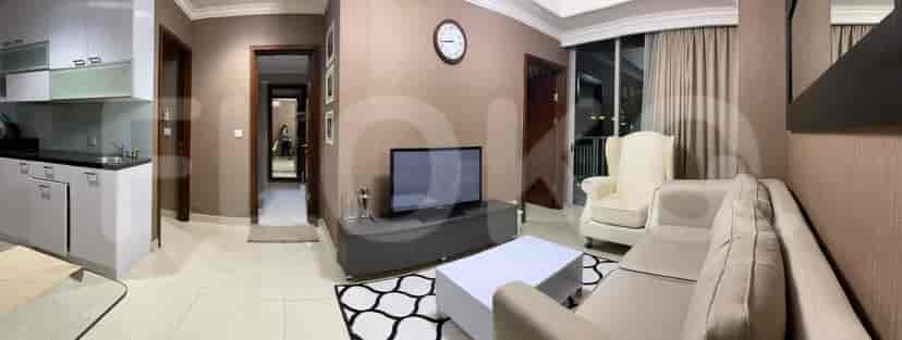 A well-lit living room with a beige sofa, white coffee table, and a TV cabinet.