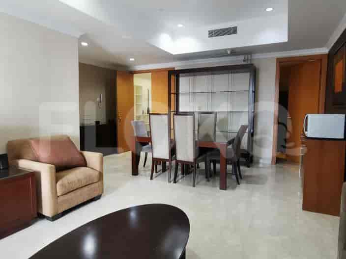 Open space with dining table, chairs, and a display cabinet.