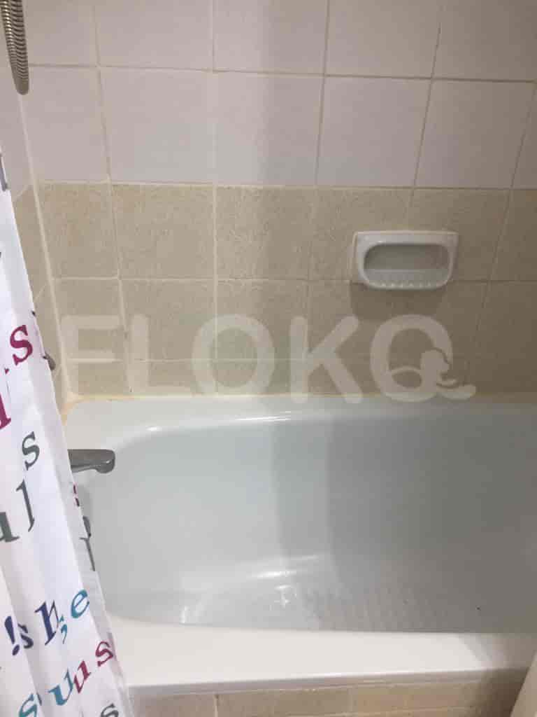A simple bathroom with a white bathtub and a shower curtain.