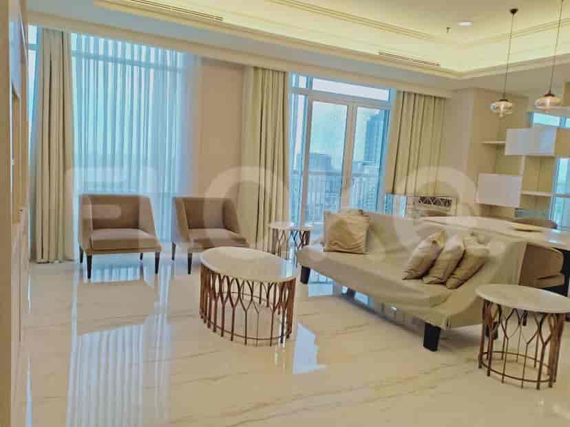 Living room with a sofa, armchairs, and a coffee table, offering a spacious and well-lit area with city views.