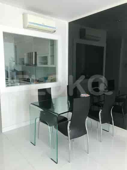 A modern dining area featuring a glass table, chairs and air conditioner.