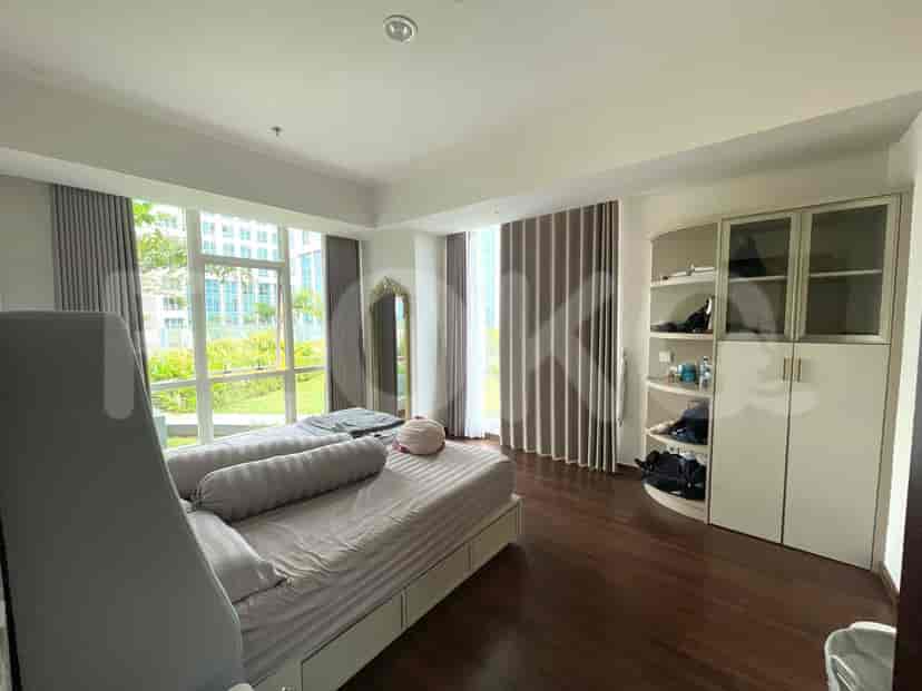 A spacious bedroom with a large window and a built-in closet.