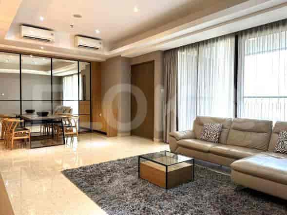Combined living and dining area with a sofa, dining table, and large windows.
