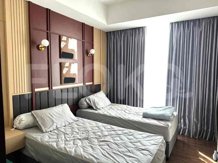 A bedroom with two beds, curtains and wall decor.