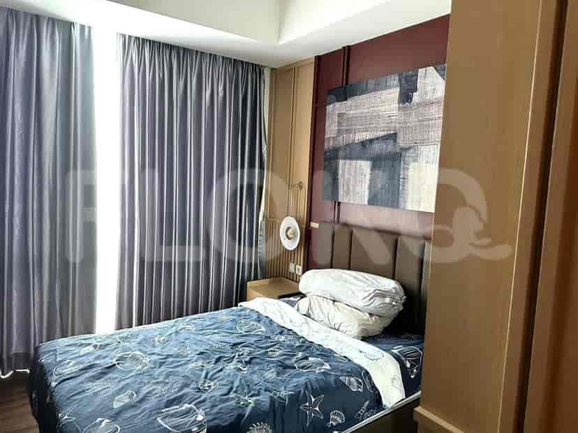 A bedroom with a bed, curtains and artwork on the wall.