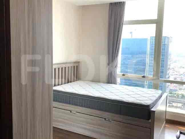 Bedroom with a double bed, large windows, and curtains.
