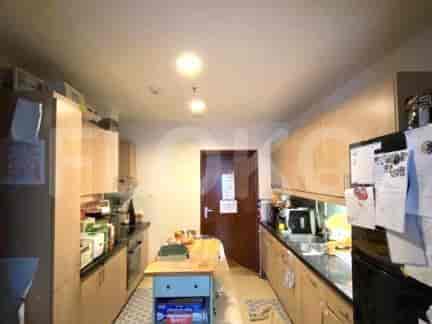 Dapur dengan lemari kayu, konter hitam, dan beberapa peralatan.