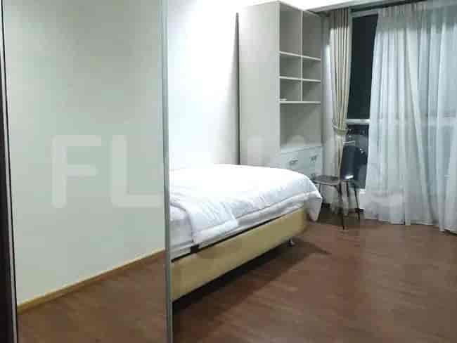 A modern bedroom with a bed, wardrobe and wooden floor.