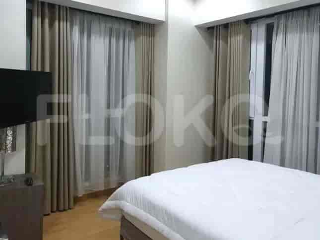A bedroom with a large bed and curtains.