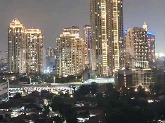 A night view of a modern cityscape with illuminated high-rise buildings.