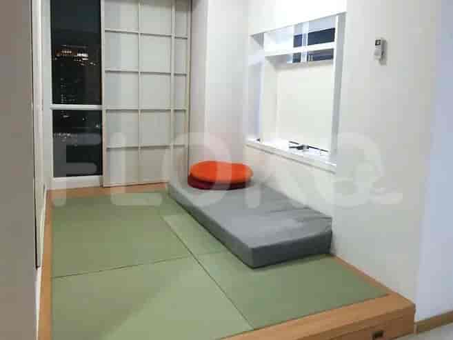 A tatami room with a mat, cushion, and window.