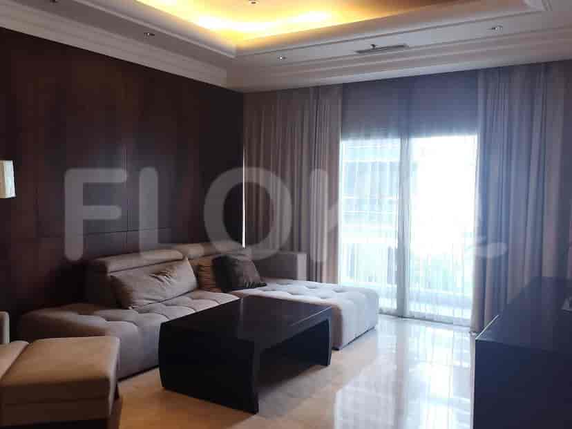 A modern living room featuring a sectional sofa, a black coffee table, and a large window with curtains.