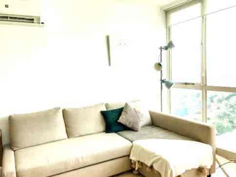 Another view of the living room with a modern sofa and floor lamp.