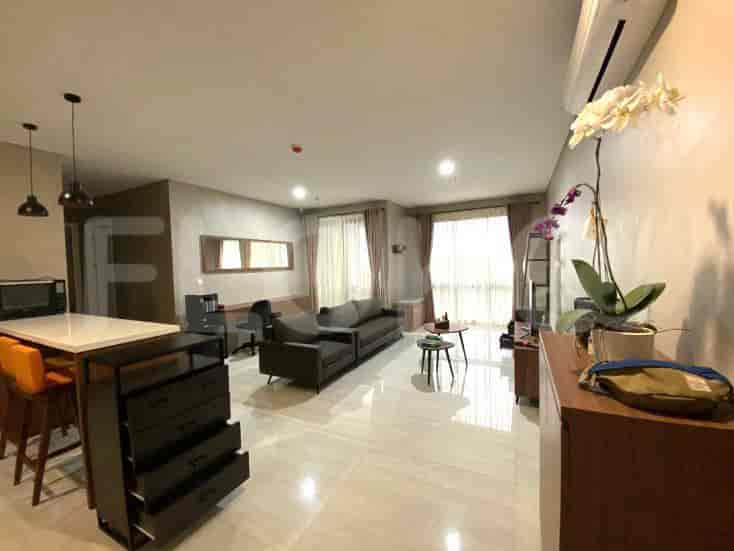 Ruang tamu dengan sofa, cermin, dan pulau dapur.