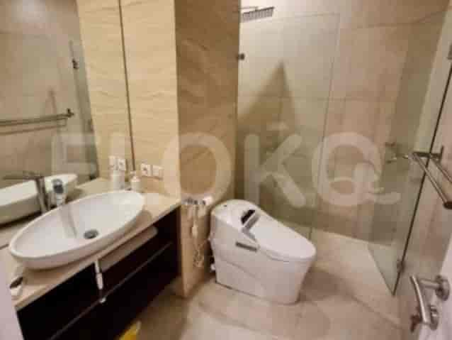 A modern bathroom with a glass shower, toilet, sink, and mirror.