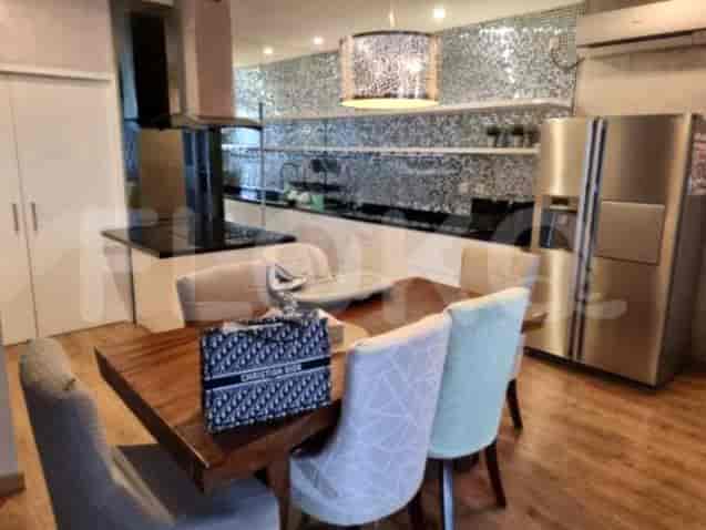 A dining area with a table, chairs, and kitchen in the background.