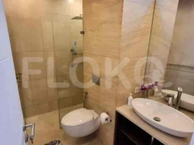 A modern bathroom with a glass shower, toilet, and sink.