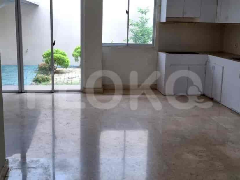 A living room with a marble floor, sliding glass doors leading to a patio, and white cabinets.