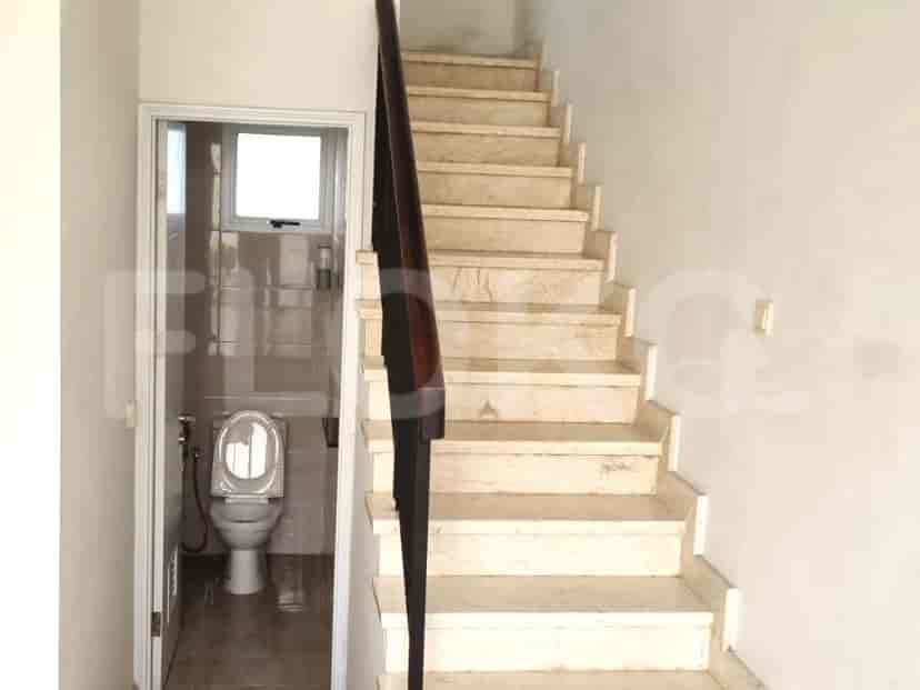 A staircase with marble steps, a wooden handrail, and a window allowing natural light.