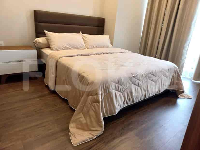Bedroom with a queen-size bed and wooden flooring.