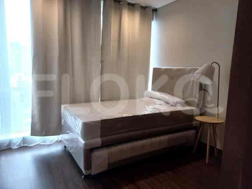 Bedroom with single bed, side table and curtains.